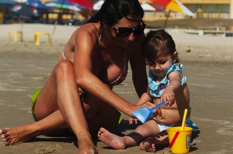 M&atilde;e e filha brincam nas areias de Cap&atilde;o da Canoa, no Litoral ga&uacute;cho