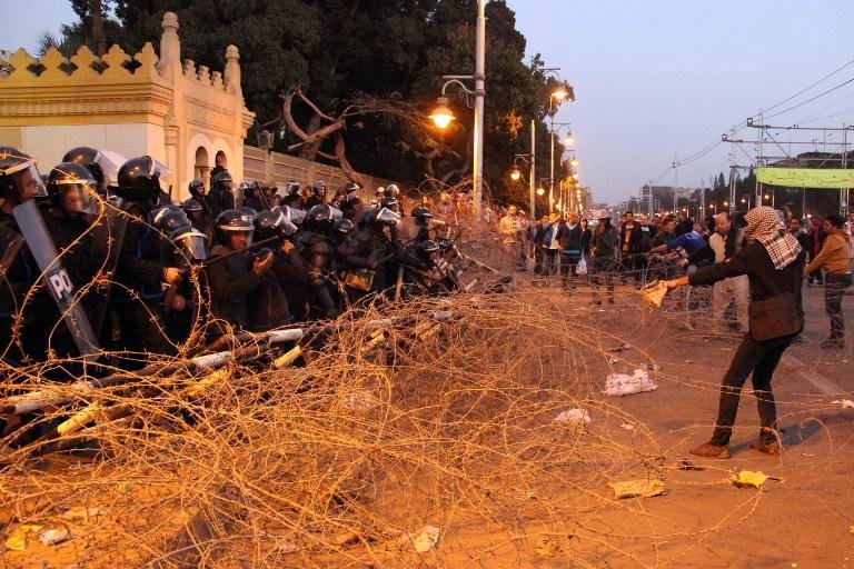 Manifestantes retiram arame farpado em frente ao pal&aacute;cio presidencial no Egito