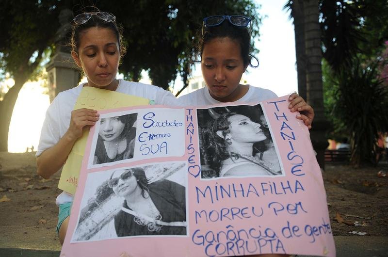 M&atilde;e e irm&atilde; mais nova mostram cartaz em homenagem a Thanise