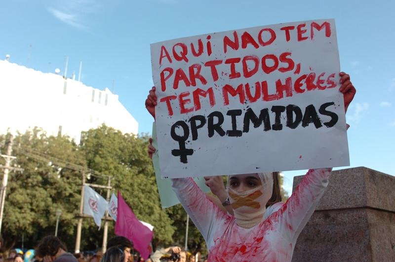 Mulher pinta a roupa de vermelho em alus&atilde;o &agrave; viol&ecirc;ncia sexual