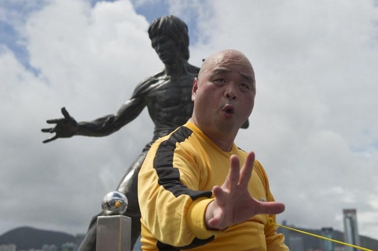 F&atilde; faz coreografia na frente de est&aacute;tua de Bruce Lee