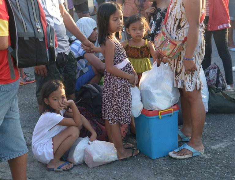 Crian&ccedil;as esperam para deixar &aacute;rea devastada nas Filipinas