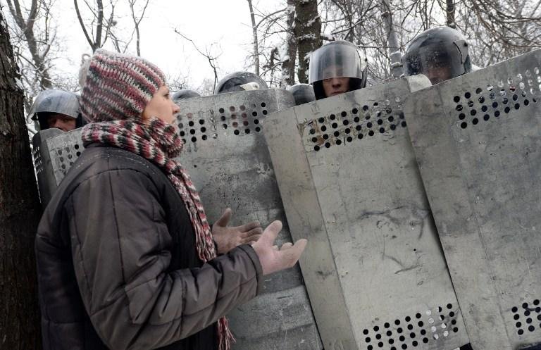  Mulher da oposi&ccedil;&atilde;o fala com a pol&iacute;cia de choque no centro de Kiev 