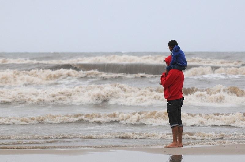 Apesar da chuva e frio, veranistas aproveitam a praia