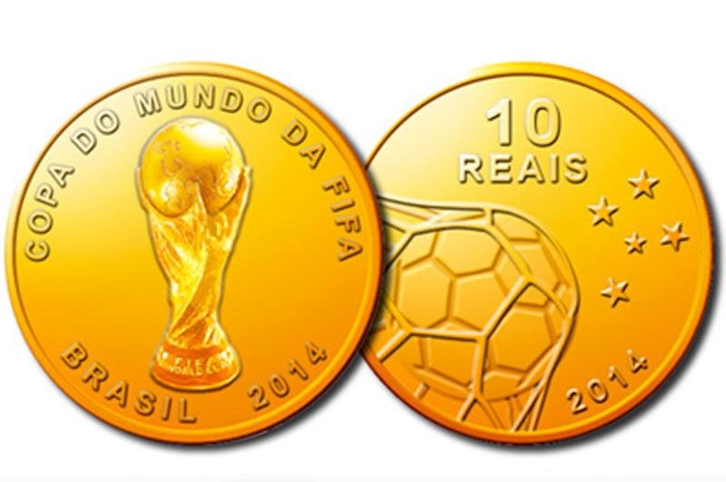 Moeda de ouro exibe o trof&eacute;u da Copa e uma bola estufando a rede