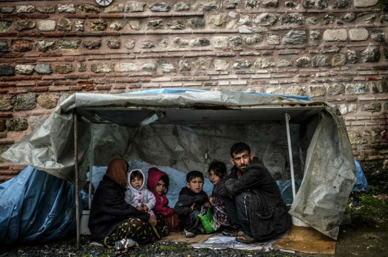 Fam&iacute;lia de refugiados s&iacute;rios de fica sob abrigo em Istambul