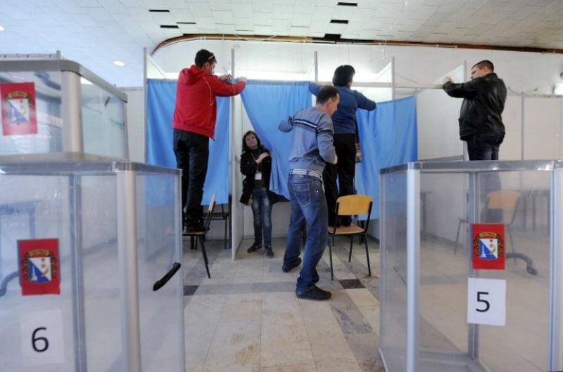 Funcion&aacute;rios preparam  cabine de vota&ccedil;&atilde;o na v&eacute;spera do referendo na Crim&eacute;ia
