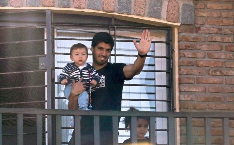 Su&aacute;rez segura o filho no colo, j&aacute; no Uruguai