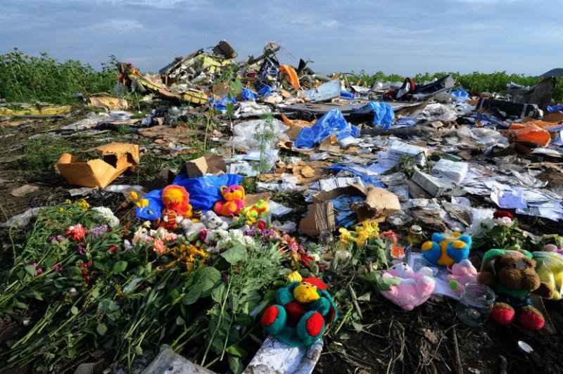 Flores e brinquedos de pel&uacute;cia s&atilde;o deixados no local da queda em tributo as v&iacute;timas