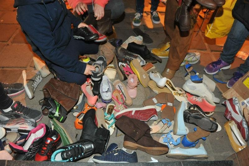 Cerca de 30 pessoas se aglomeraram diante de oito caixas de papel&atilde;o cheias de sapatos