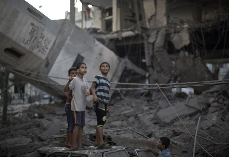 Crian&ccedil;as observam pr&eacute;dio de mesquita destru&iacute;da em Gaza