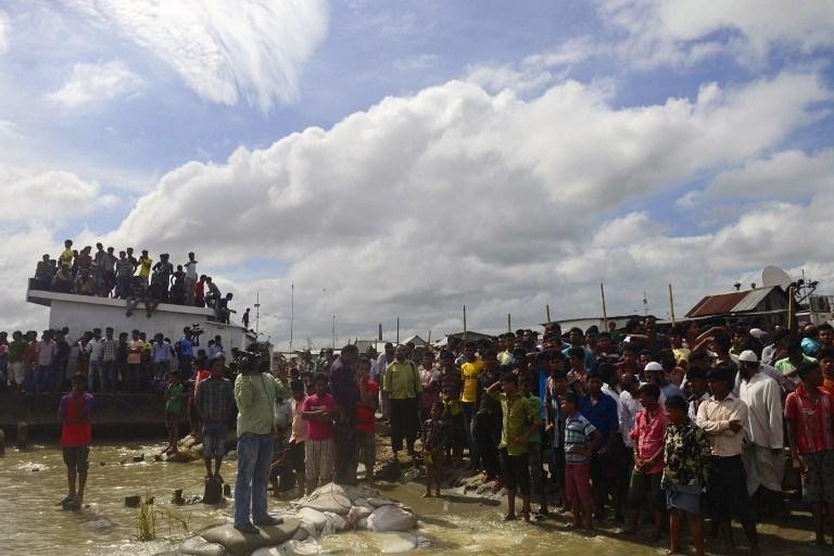 Pessoas se re&uacute;nem na praia onde balsa teria afundado