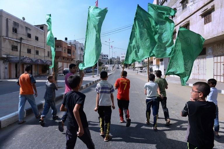 Meninos palestinos carregam bandeira do Hamas durante funeral