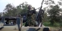 Abubakar Shekau usa roupas de camuflagem e botas e atira para o alto