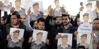 Ativistas carregam cartazes com o retrato do piloto Jordanian Maaz al- Kassasbeh , morto pelo Estado Islâmico 