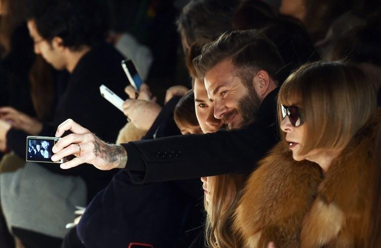 Enquanto a esposa apresentava o desfile, David Beckham se divertia com os filhos na primeira fila