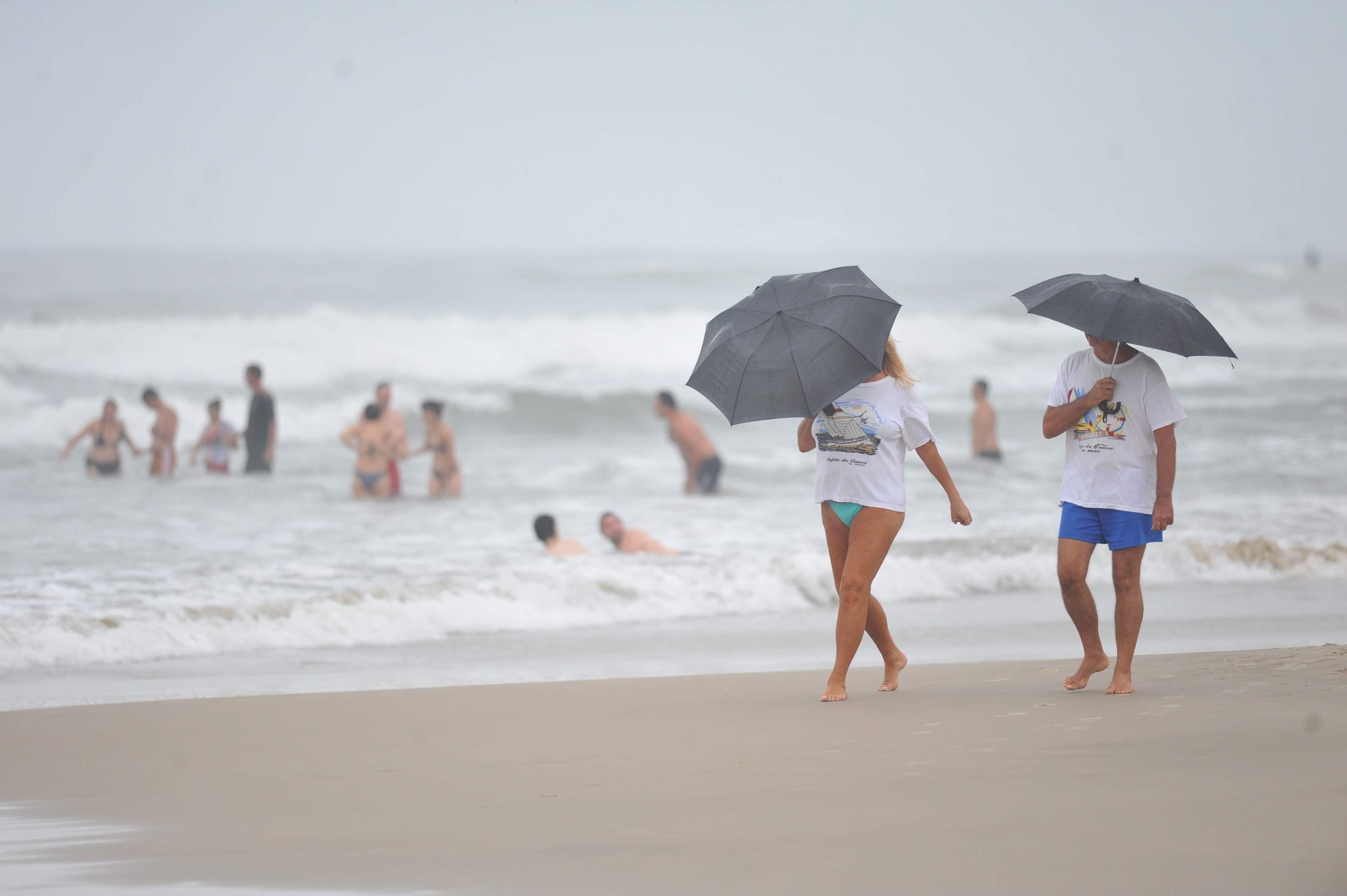 Banhistas ignoram mau tempo e aproveitam orla de Cap&atilde;o da Canoa
