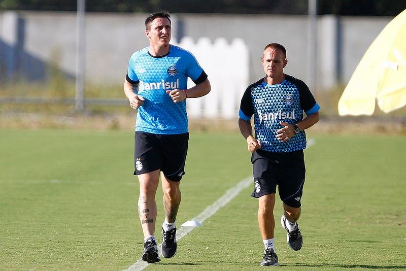 Cristian Rodr&iacute;guez corre ao lado de um integrante da comiss&atilde;o t&eacute;cnica