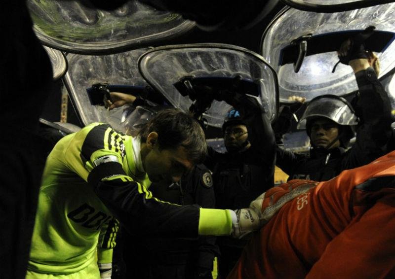 Jogadores saem de campo protegidos pela policia