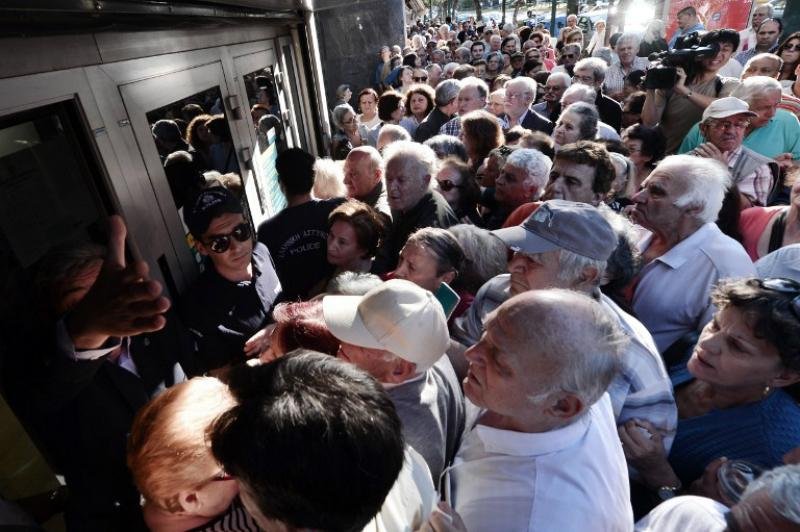 Aposentados esperam em frente a banco para retirar dinheiro 
