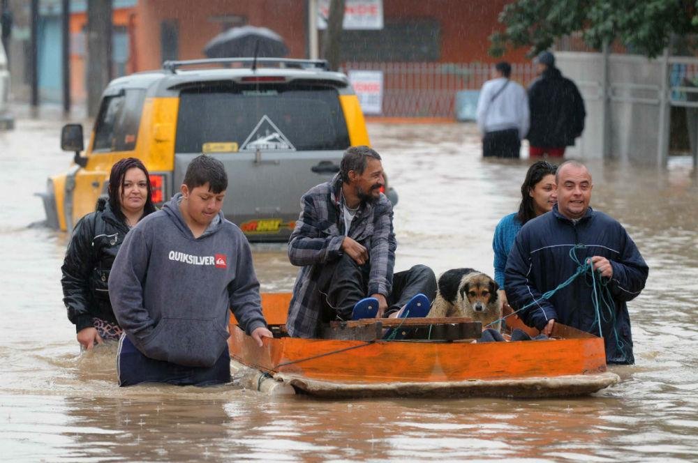 Na pressa, popula&ccedil;&atilde;o salva o que pode em barcos improvisados