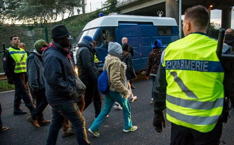 Migrantes que falharam ao tentar chegar ao Reino Unido sendo encaminhado pela pol&iacute;cia