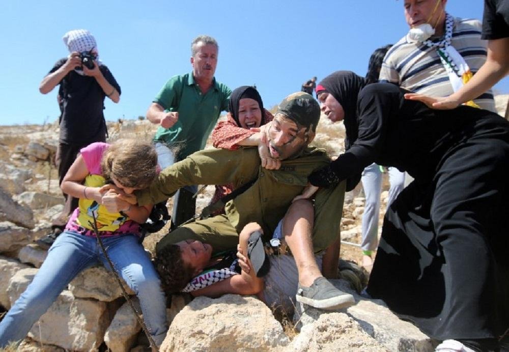 Ativistas pr&oacute;-palestinas apressam-se em agarrar o soldado