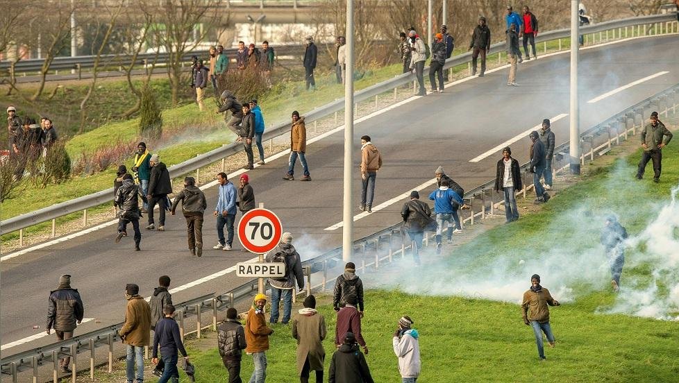 For&ccedil;as policiais francesas tentam dispersar migrantes e refugiados na estrada do Eurot&uacute;nel em Calais na Fran&ccedil;a