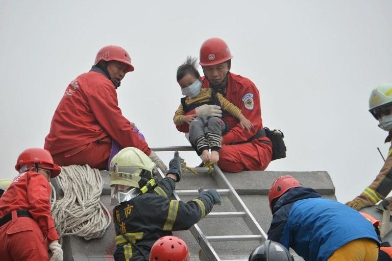 Equipes de socorro ajudam a retirar crian&ccedil;a de pr&eacute;dio que desabou