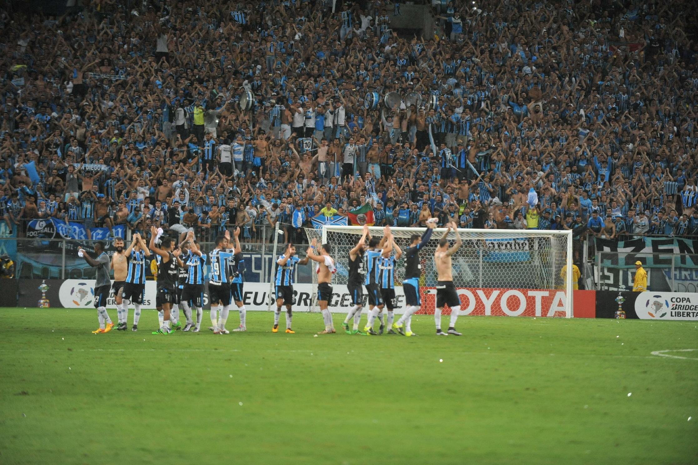 Torcida e time comemoram juntos ao final da partida o resultado de 4x0