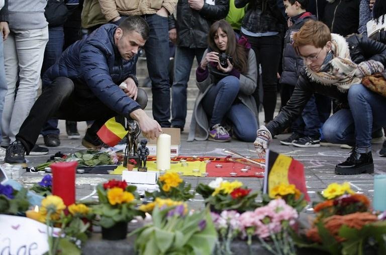 Pessoas acendem velas em memorial improviaso na Place de la Bourse ap&oacute;s ataques que deixaram mais de 30 mortos em Bruxelas