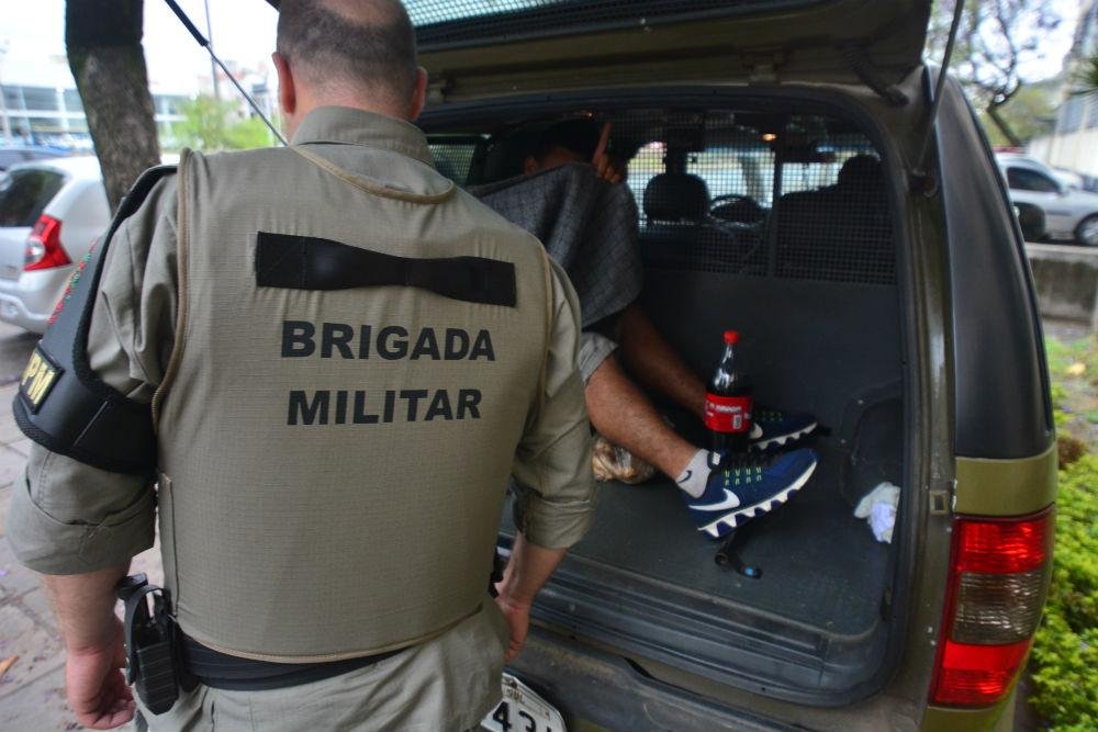Um preso segue em viatura da Brigada Militar na frente da 2&ordf; DPPA