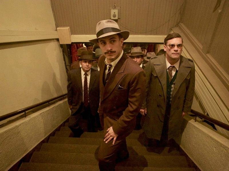 Ator Gael Garcia Bernal (centro) interpreta policial que persegue Pablo Neruda