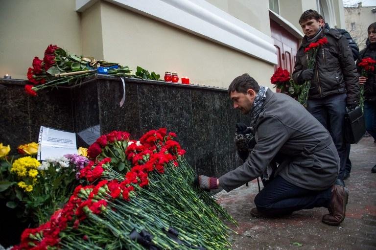 Pessoas depositam flores em homagem a membros do coro mortos em acidente