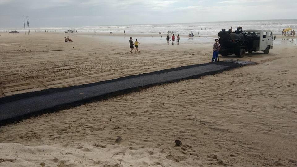 Passarela de asfalto na areia da praia de Cap&atilde;o, mas retirada pela prefeitura