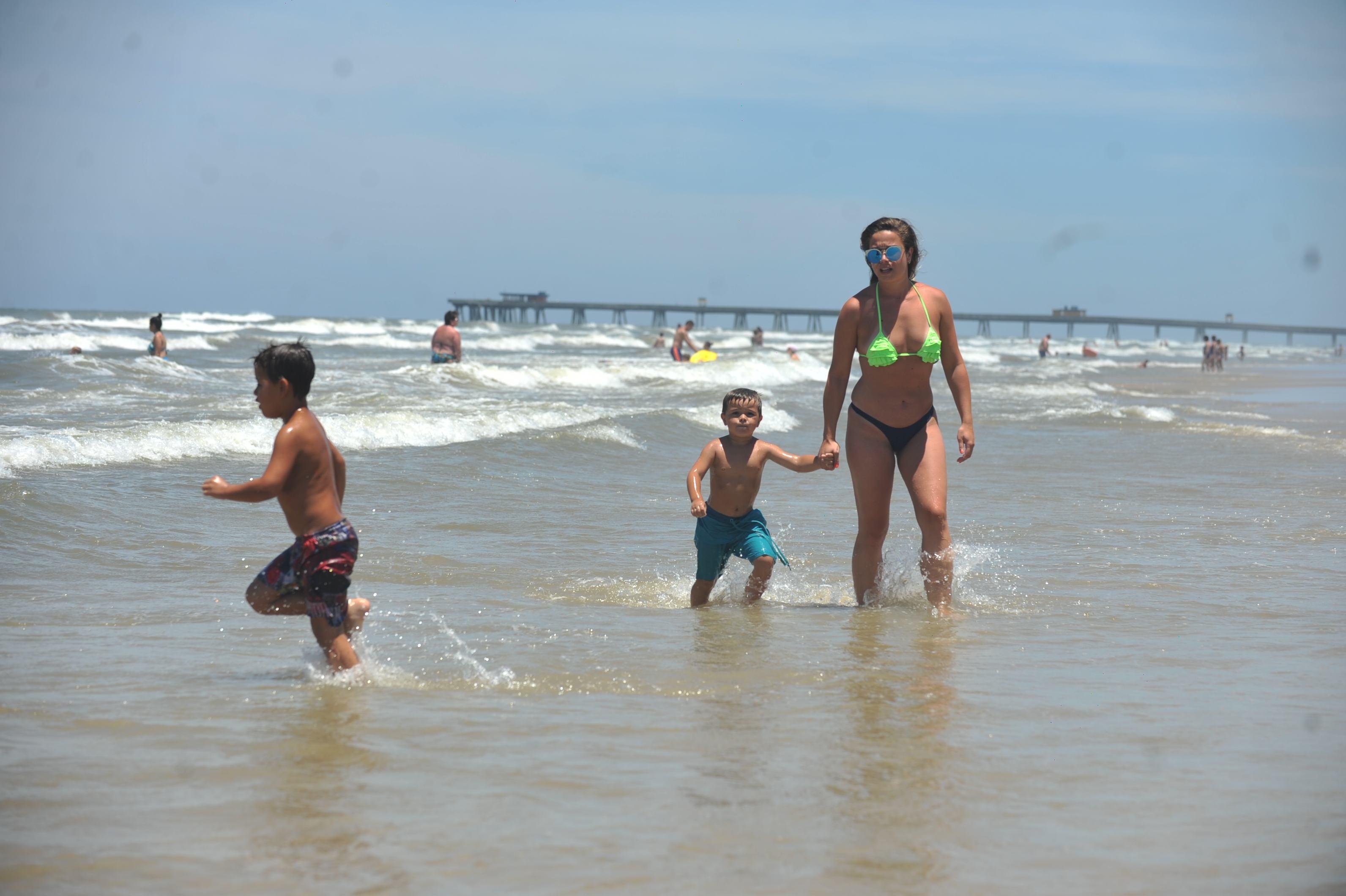 Veranistas se refrescam do calor brincando no mar