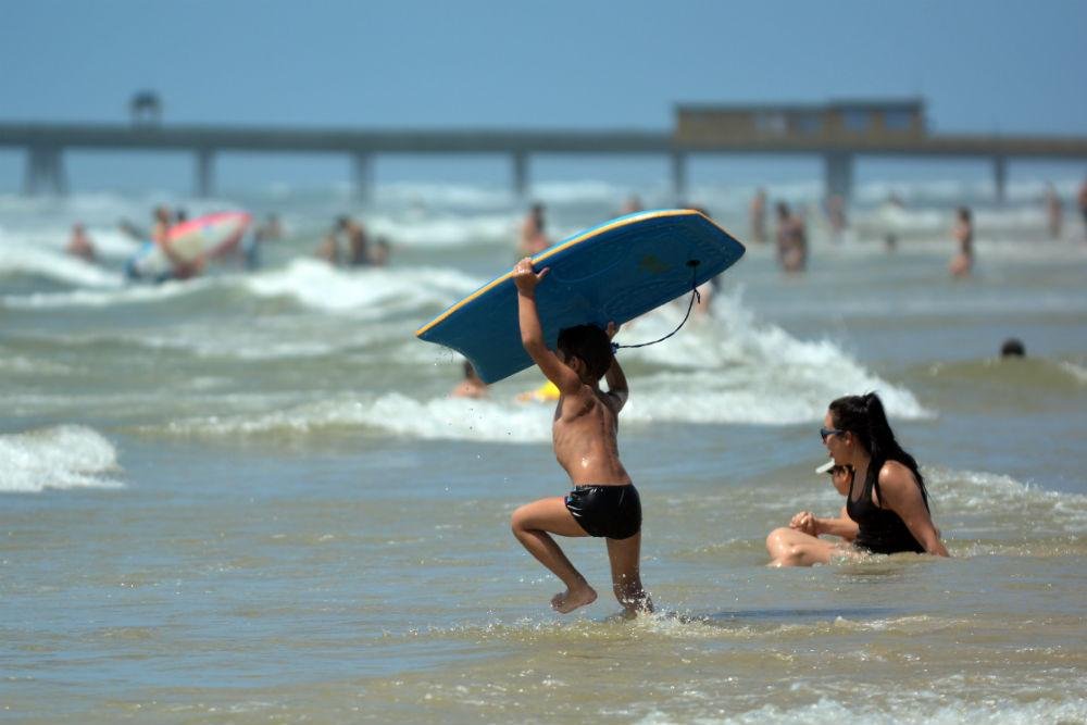 Sol e pouco vento levou muitos banhistas a beira da praia de Tramanda&iacute;