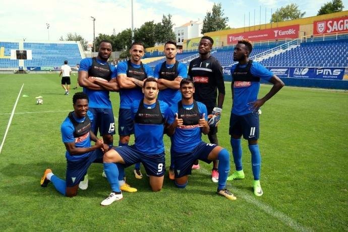 Bruno Gomes, ajoelhado entre dois companheiros