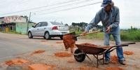 Sérgio Alberto Martins, conhecido como Zelador das Ruas, tapa buracos para que não causem acidentes