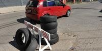 Moradores da rua Comendador Coruja colocaram cavalete do Dmae e oito pneus para chamar a atenção dos motoristas para um buraco