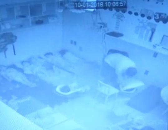 Imagem mostra funcion&aacute;ria pressionando travesseiro contra crian&ccedil;a de 2 anos