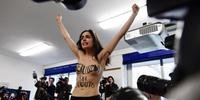 Mulher protesta durante voto do candidato Silvio Berlusconi