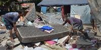 Pessoas desabrigadas dormem em barracas ou sob toldos colocados perto das ruínas de suas casas ou dos abrigos