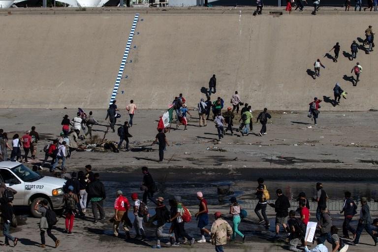 Centenas de migrantes tentam pular cerca fronteiri&ccedil;a entre M&eacute;xico e EUA