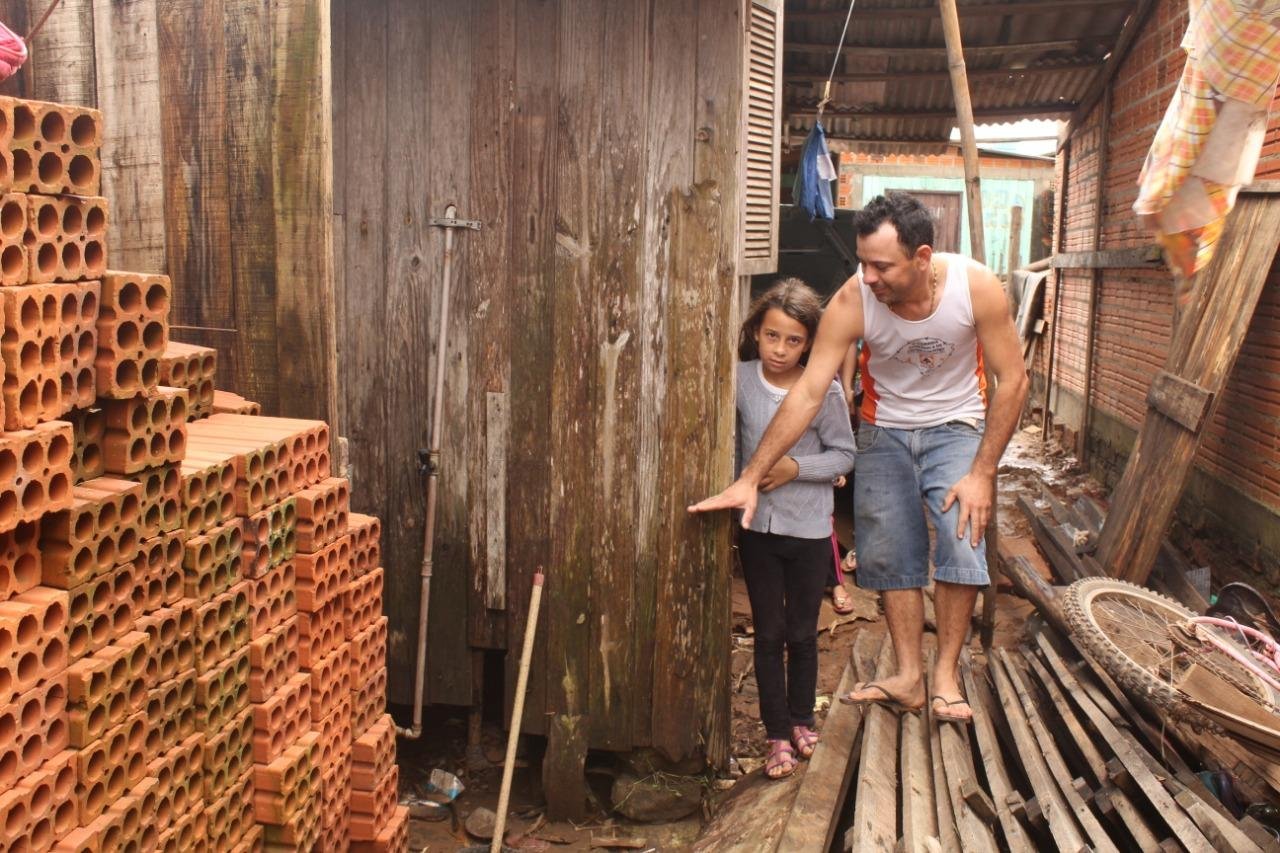 Morador mostra a altura que a &aacute;gua atingiu