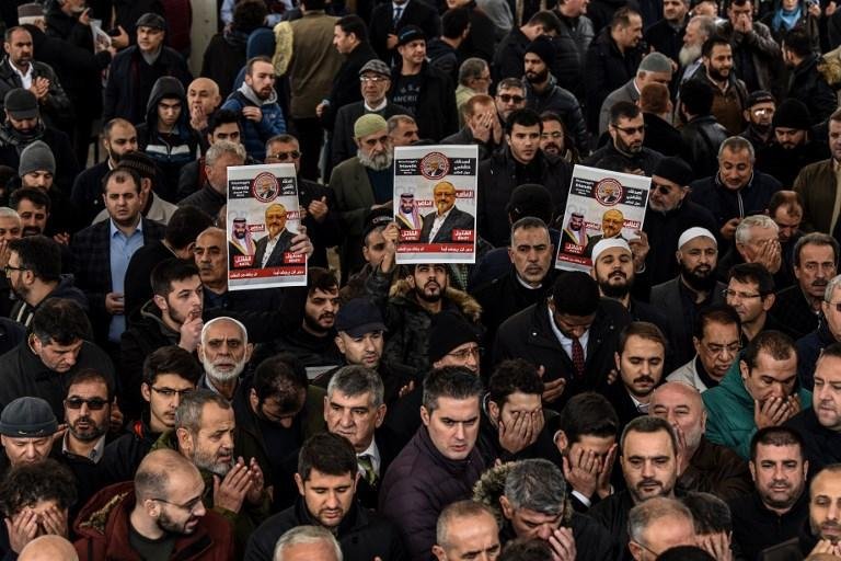 Pessoas seguraram faixas de Jamal Khashoggi durante uma ora&ccedil;&atilde;o f&uacute;nebre simb&oacute;lica para o jornalista saudita