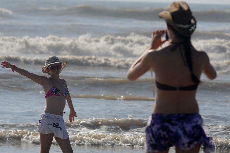 Tempo bom, com sol entre nuvens e pouco vento, atraiu veranistas &agrave; beira da praia