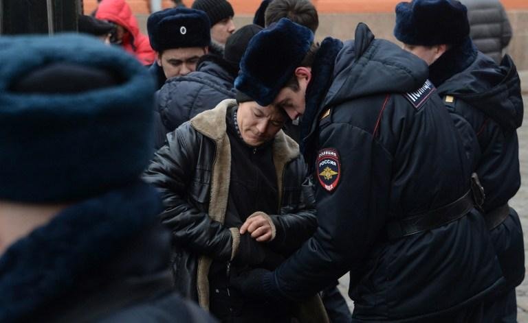 Policial revista turista em pra&ccedil;a de Moscou