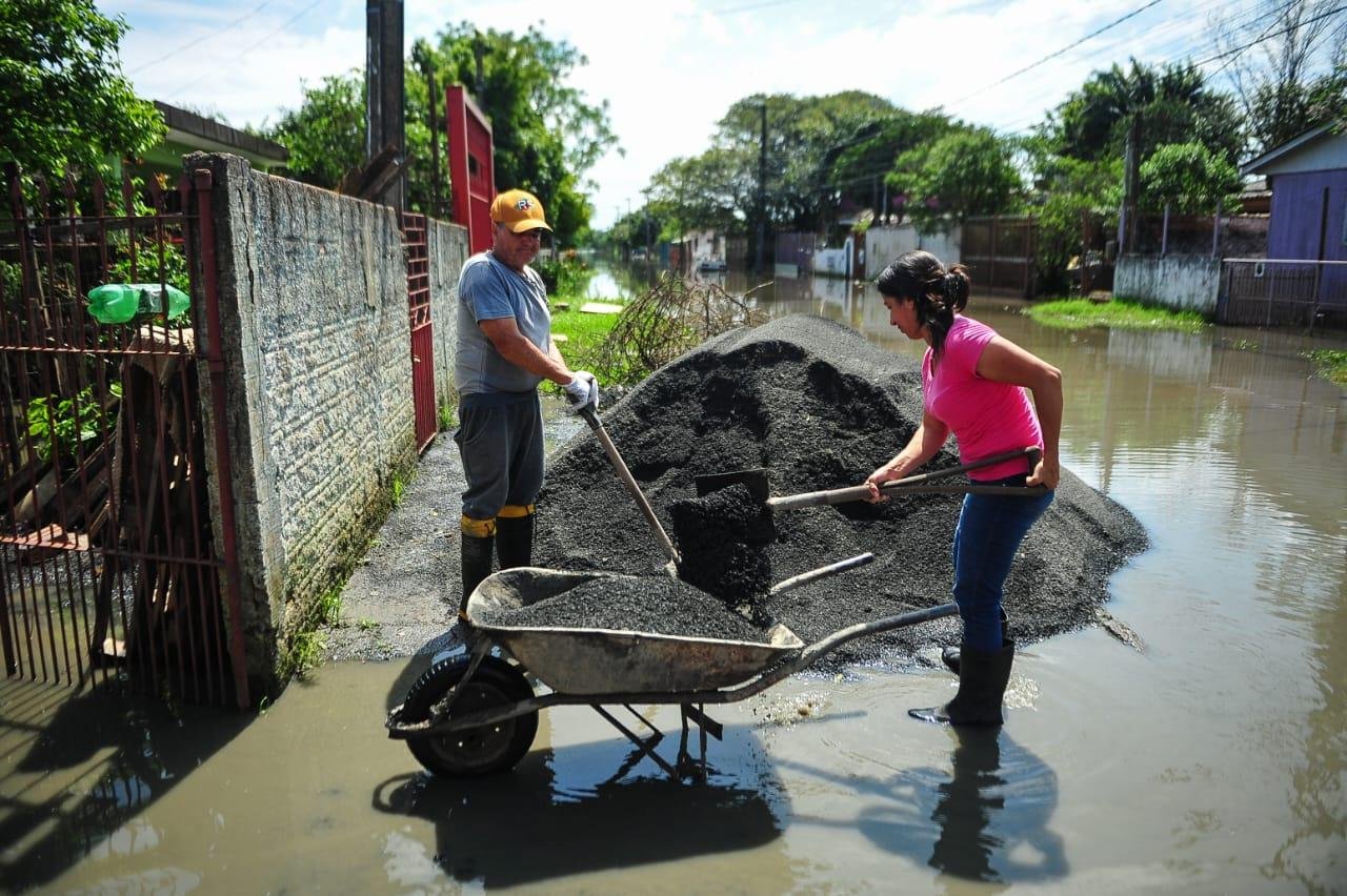 As &aacute;guas ainda cobrem ruas do bairro Am&eacute;rica em Alvorada. Moradores colocam aterro para evitar mais alagamentos.