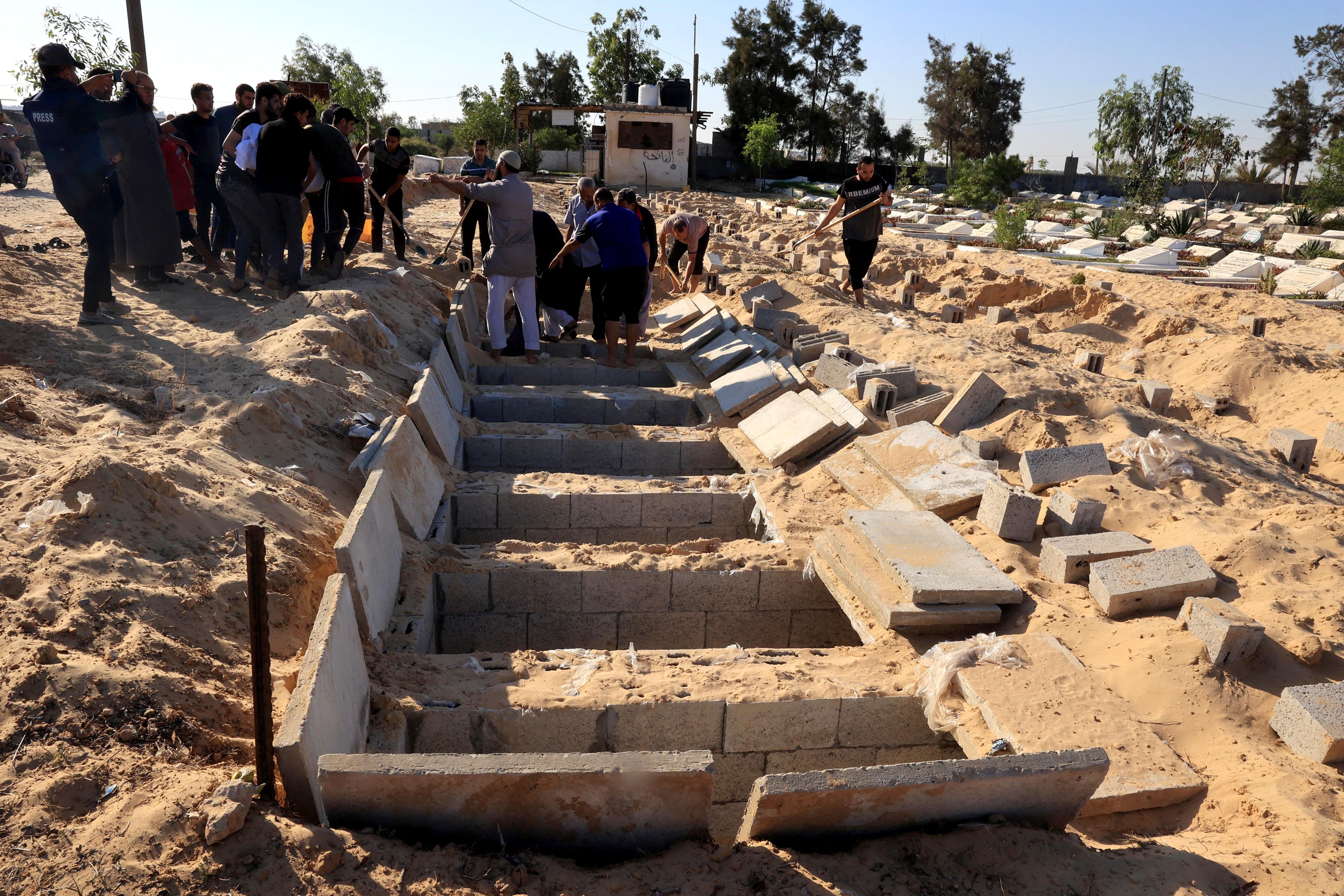 Covas escavadas para receber mortos no conflito, nas proximidades de Rafah, Gaza